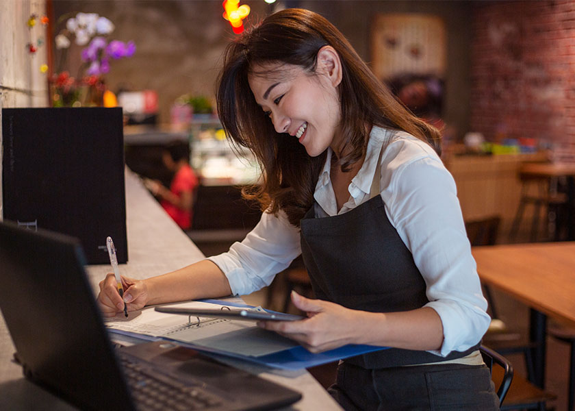 Small business owner reviewing her financial planning documents on a laptop.